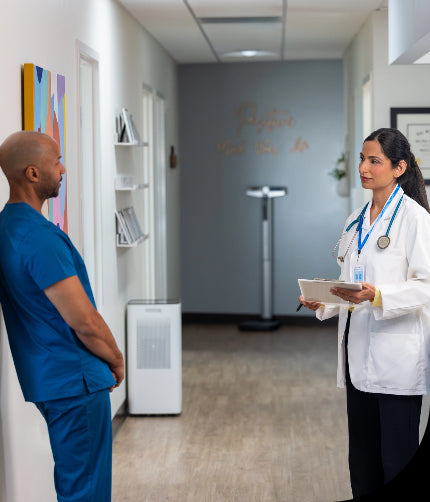 two doctors talking in a office near an air purifier